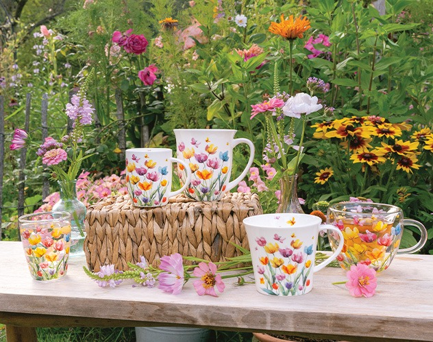 Collectie 'Fantasy flowers' mokken en glazen met vrolijk bloemenmotief tussen veldbloemen.