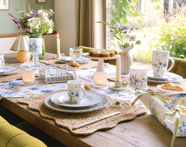 Gezellige tuintafel gedekt met 'Wild meadow flowers' servies, mokken en veldbloemen.