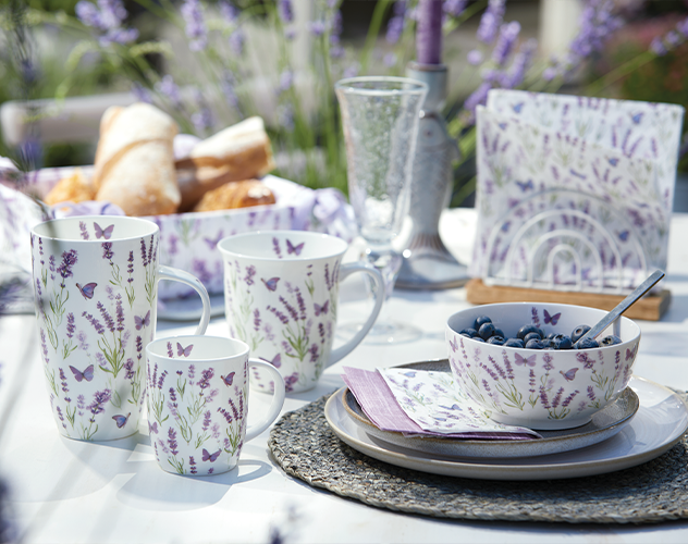 Mokken en kom met 'Butterfly lavender' motief op een buitentafel.