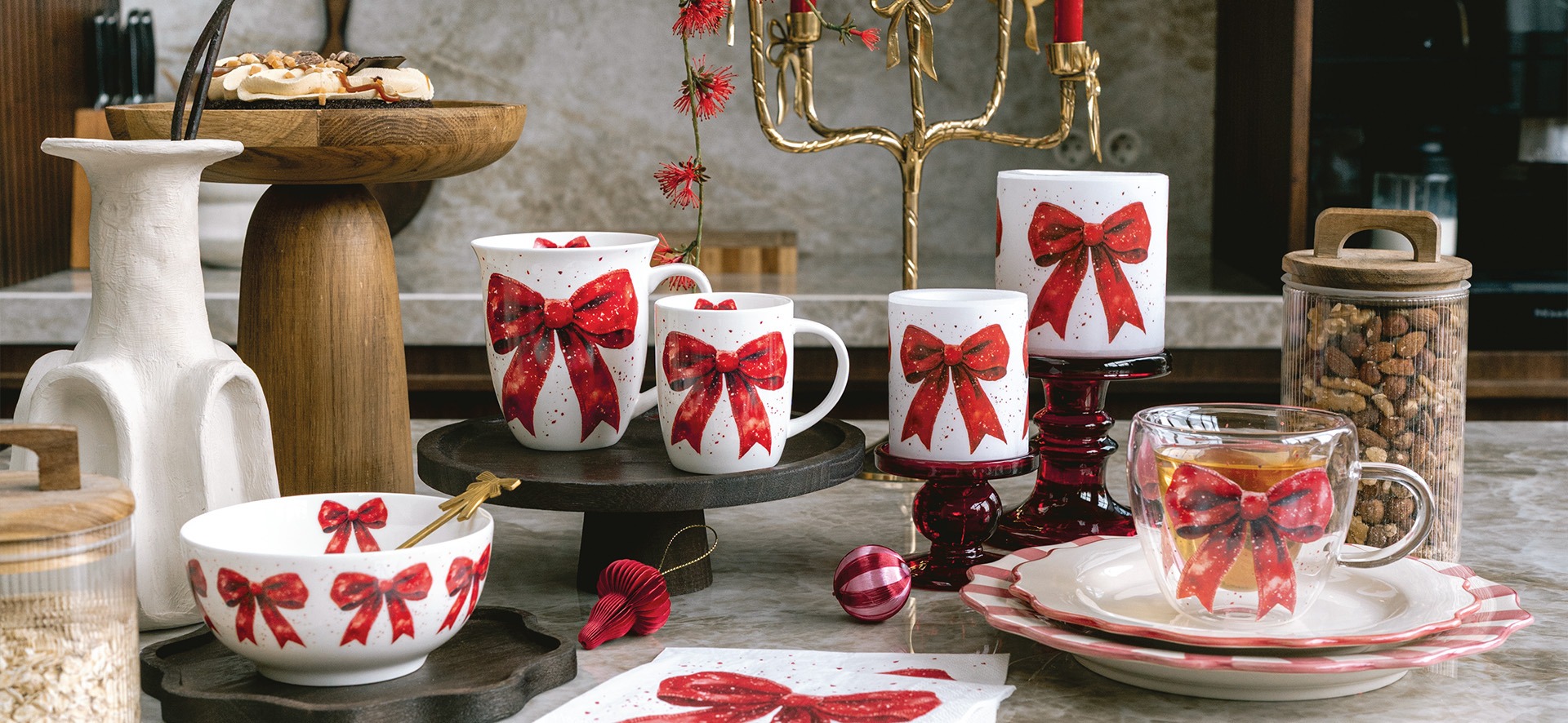 Christmas kitchen scene with Fancy bow mugs, bowl, candles, double-walled glass and napkin with a red bow