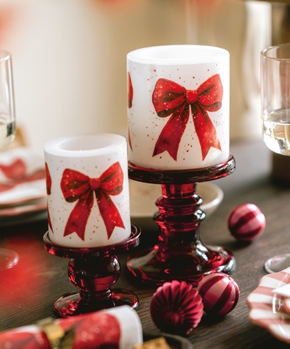 Christmas kitchen scene with Fancy bow mugs, bowl, candles, double-walled glass and napkin with a red bow